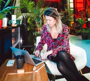 Eine Frau übt ihren Nebenjob für Studenten am Laptop aus