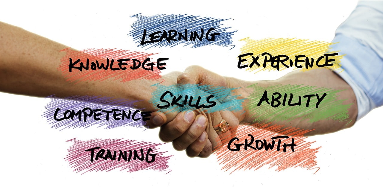 Auf dem Bild sieht man einen Handschlag mit verschiedene Wörter wie "Learning" und "Training".