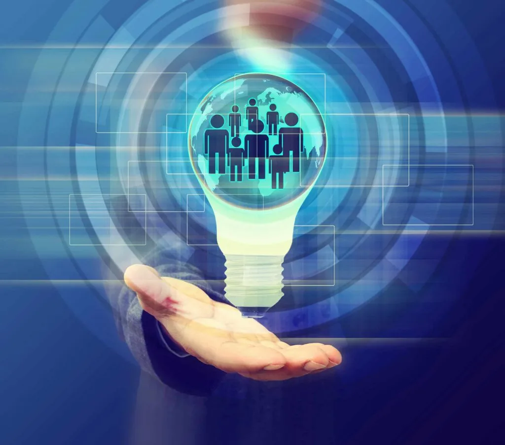 Hand eines Geschäftsmannes, darüber schwebt eine Glühbirne mit Menschenfiguren im Inneren.