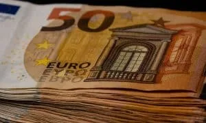 Nahaufnahme eines dicken Stapels mit 50-Euro-Scheinen. Schwarzer Hintergrund.