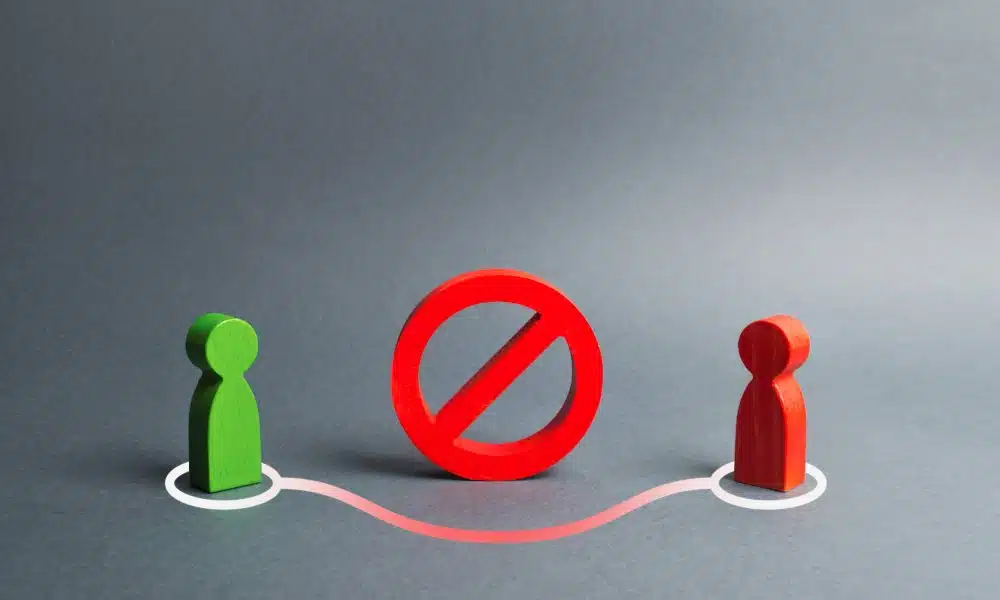 Eine rote und eine grüne Spielfigur sind durch eine rot-weiße Linie verbunden, und ein Halt-Schild ist zwischen ihnen. Grauer Hintergrund.