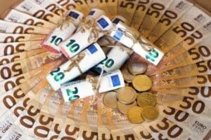 50-Euro-Scheine in einem Kreis gefächert, in der Mitte zusammengerollt und mit Schnur zugebunden, 20- und 20-Euro-Scheine mitsamt Münzen.